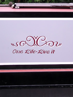 Image of signwriting on a narrow boat reading "one life live it"