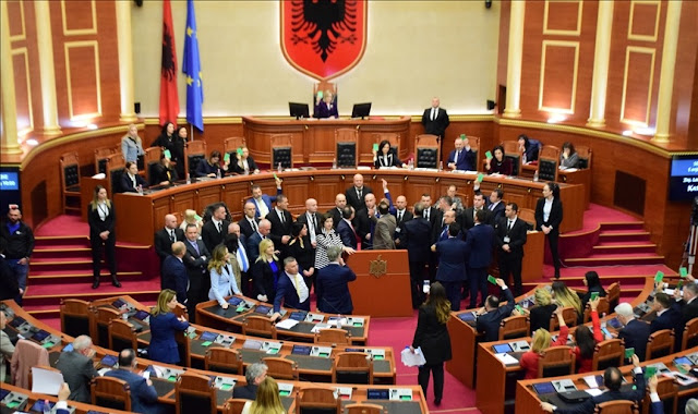 In the Albanian parliament, the tensed deputies debating fiercely among themselves near the lectern