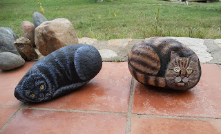 Piedra pintada con un gato negro.