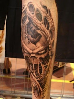 biomechanical 3d tattoo on the calf: an alien head