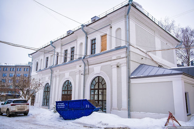 Старое белое здание с арочными окнами