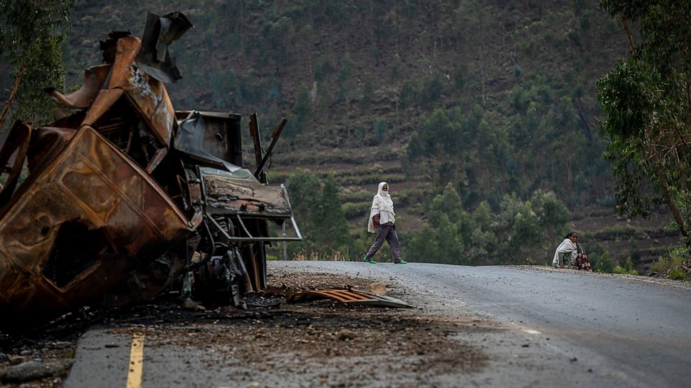 FILE - A man crosses near a destroyed truck on a road leading to the town of Abi Adi, in the Tigray region of northern Ethiopia on May 11, 2021. A spokesman for Tigrayan authorities said Tuesday, Sept 20, 2022 that Eritrea had launched a full-scale offensive along the country’s border with northern Ethiopia. (AP Photo/Ben Curtis, File)