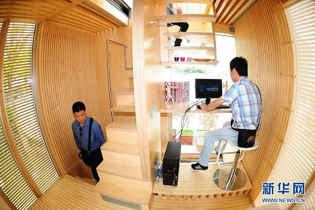 Interior of the sustainable micro house with two people walking around