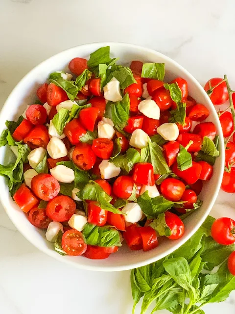 My Easy Chopped Cherry Caprese Salad is loaded with ripe cherry tomatoes, fresh basil, and fresh mozzarella pearls and drizzled with a balsamic glaze.