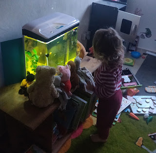 Enjoying the fish with her teddies