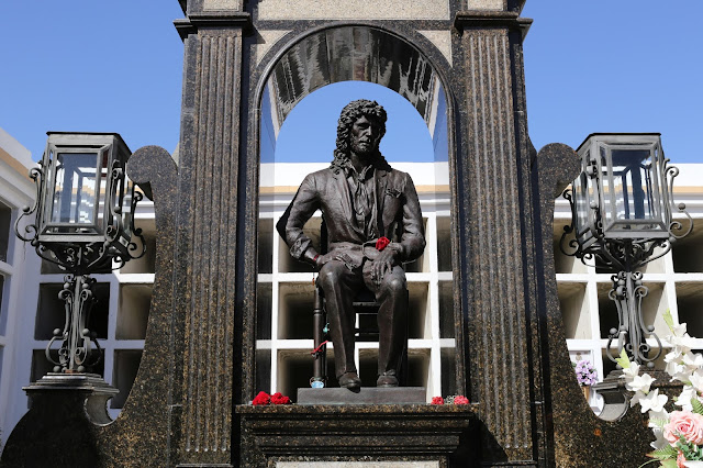 Tumba de piedra negra con la estatua de Camarón de la Isla en un cementerio.