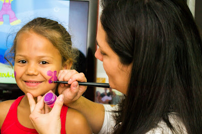 Mãe pintando filha numa brincadeira feliz