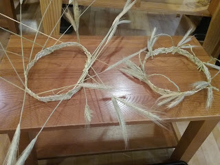 Two headbands of 9-strand plaited straw, one decorated with long stalk of rye, the ogher with loops of plaited straw and clusters of rye heads.