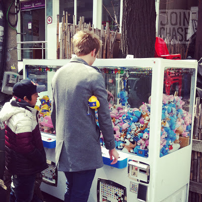 A foreign man and Korean child playing claw machines in Seoul, South Korea.