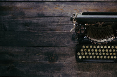 black Corona typewriter on brown wood planks