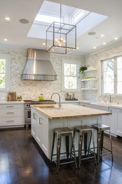 white kitchen with dark wood floors square gold glass pendant lights marble backsplash wood countertop