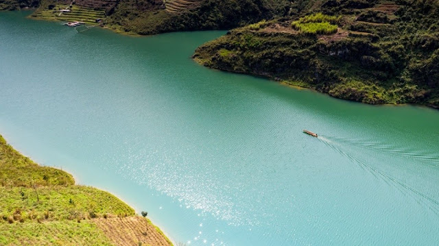 Nằm dưới chân những ngọn núi tai mèo hiểm trở của Hà Giang, dòng sông Nho Quế quanh năm êm đềm chảy giữa những vách đá, tạo thành một đường biên giới màu xanh biếc giữa đèo Mã Pí Lèng và đường Săm Pun. 