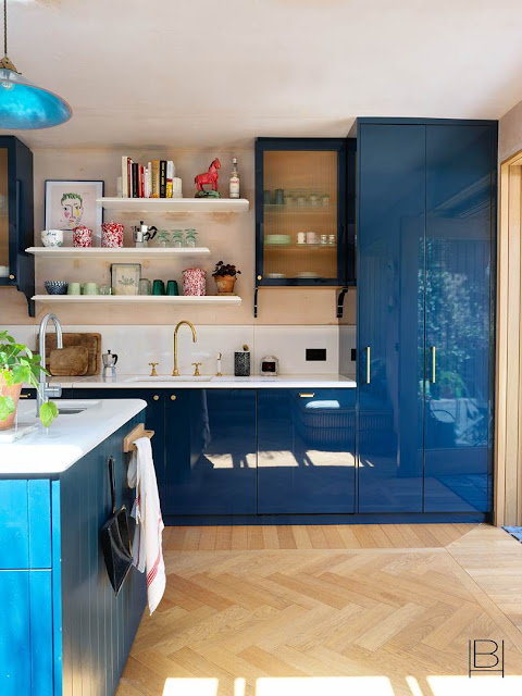 Beata Heuman kitchen and eat in dining room with shiny blue kitchen cabinets and open shelves