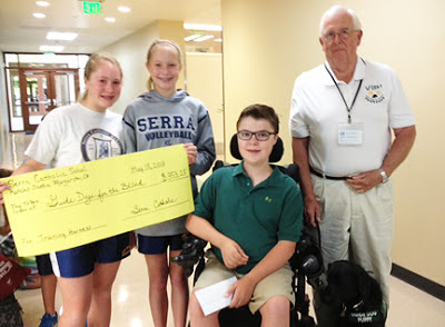 Serra Catholic School students hold up a check for funds they raised from their recycle program to benefit GDB.