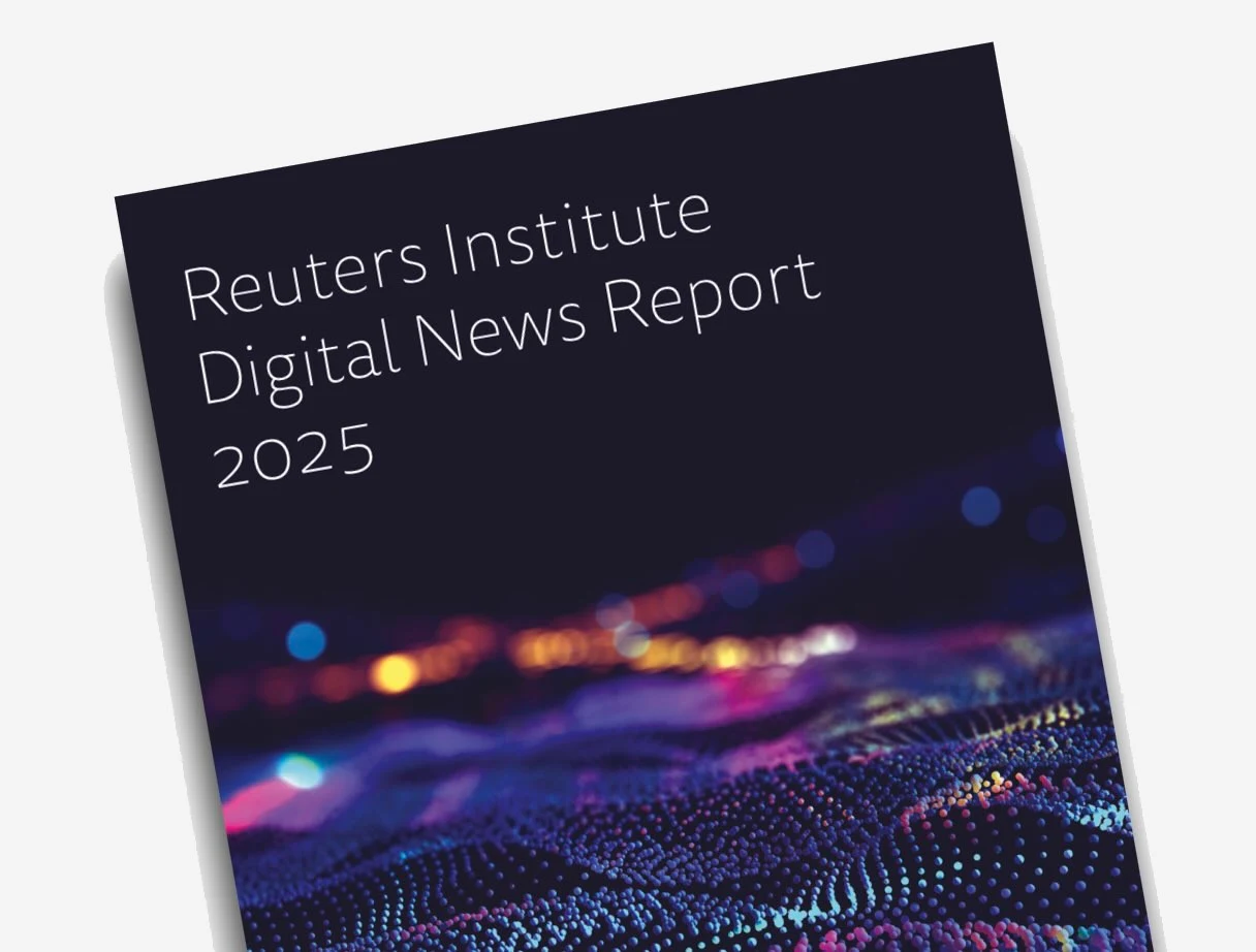 The cover of a dark-colored report titled "Reuters Institute Digital News Report 2025" in white text, angled slightly. The lower part of the cover features an abstract digital design with blurred lights and a textured, dotted surface in shades of blue, purple, and orange.