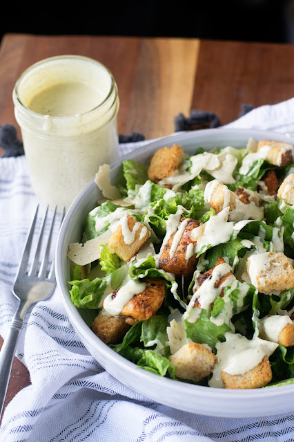 A bowl of the Chicken Caesar Salad with the Anchovy-Free Dressing to the side.