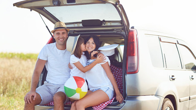 Mom, Dad, and daughter sitting in the back of car