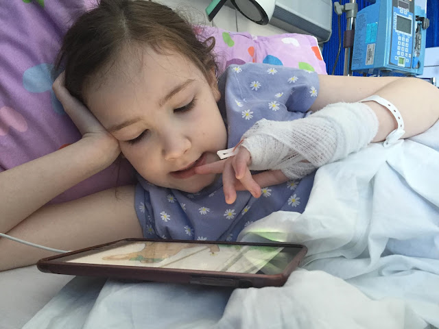 girl in hospital bed with cannula in