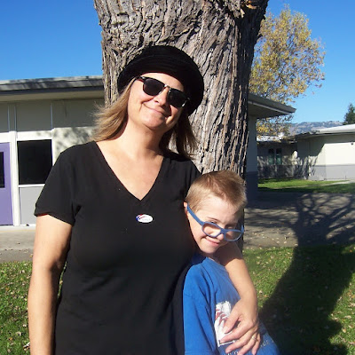 Lisa and her son at his elementary school, standing by a tree, and smiling