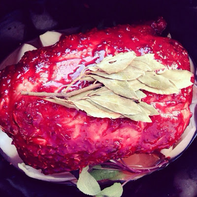 ready for the slow cooker: pork joint covered in wet and dry blackberry spice rub, sage, mustard, endive,chicory,onion,