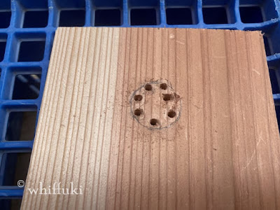 木板に、ドリルであけた小さな穴がいくつかあいている。