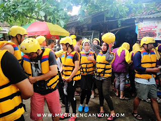 pemasangan perlengkapan body rafting oleh pemandu.