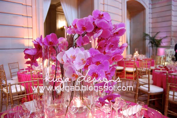  surrounded by clear cylinder vases with floating candles in them