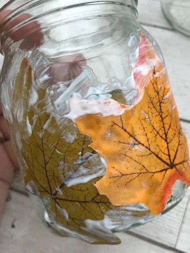 Leaves being glued to a jar