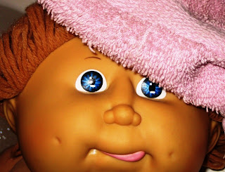 Cabbage Patch Kid with towel over head and right eye