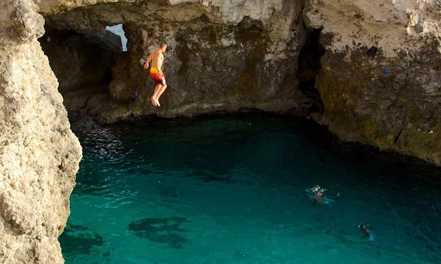 A man Jumps to a water at blue hole spring jamaica