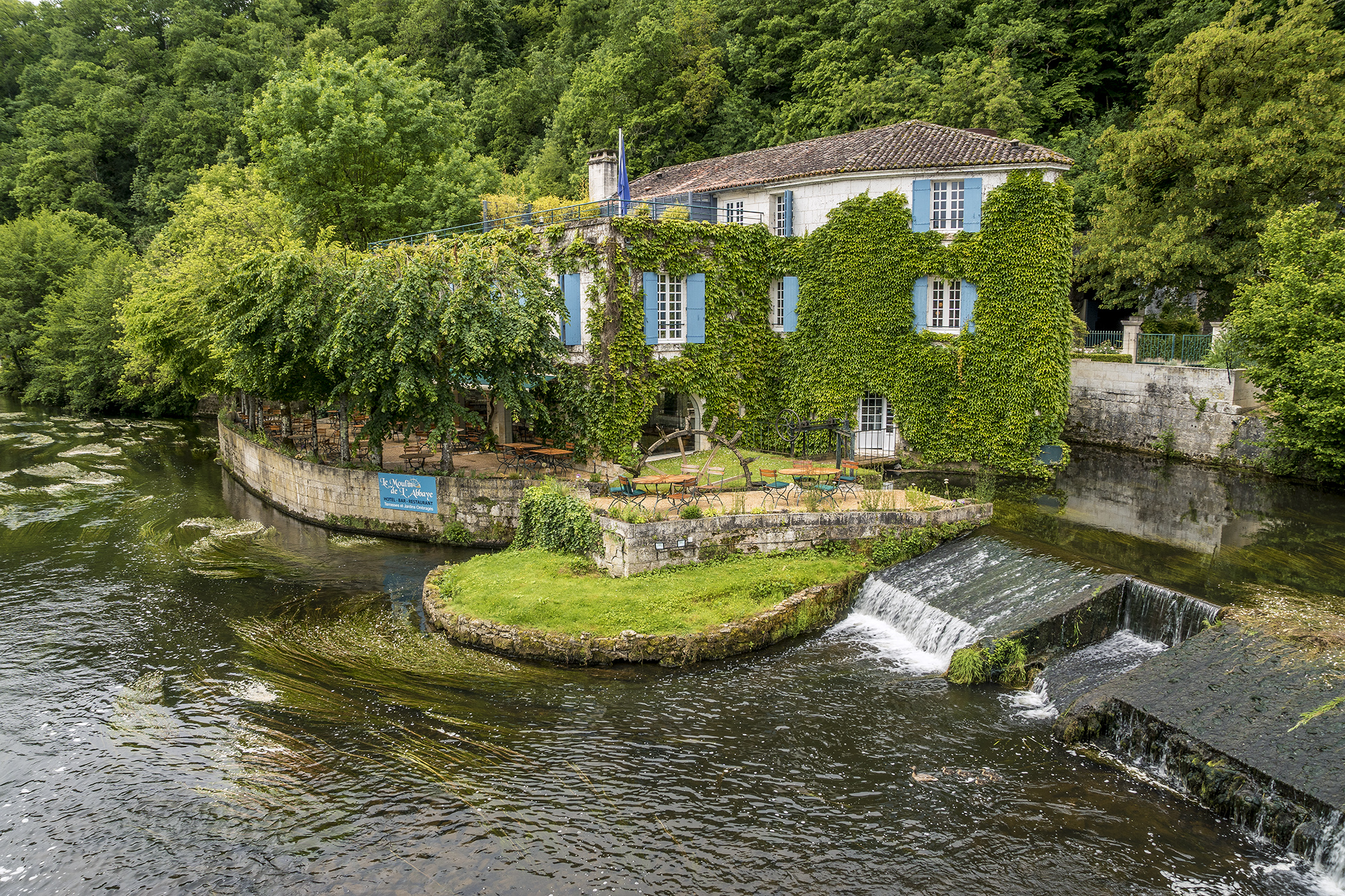 Vista de Brantome, en el Perigord, Francia, del puente de piedra y la abadía benedictina de Saint-Pierre