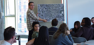 Person writing on whiteboard in front of people