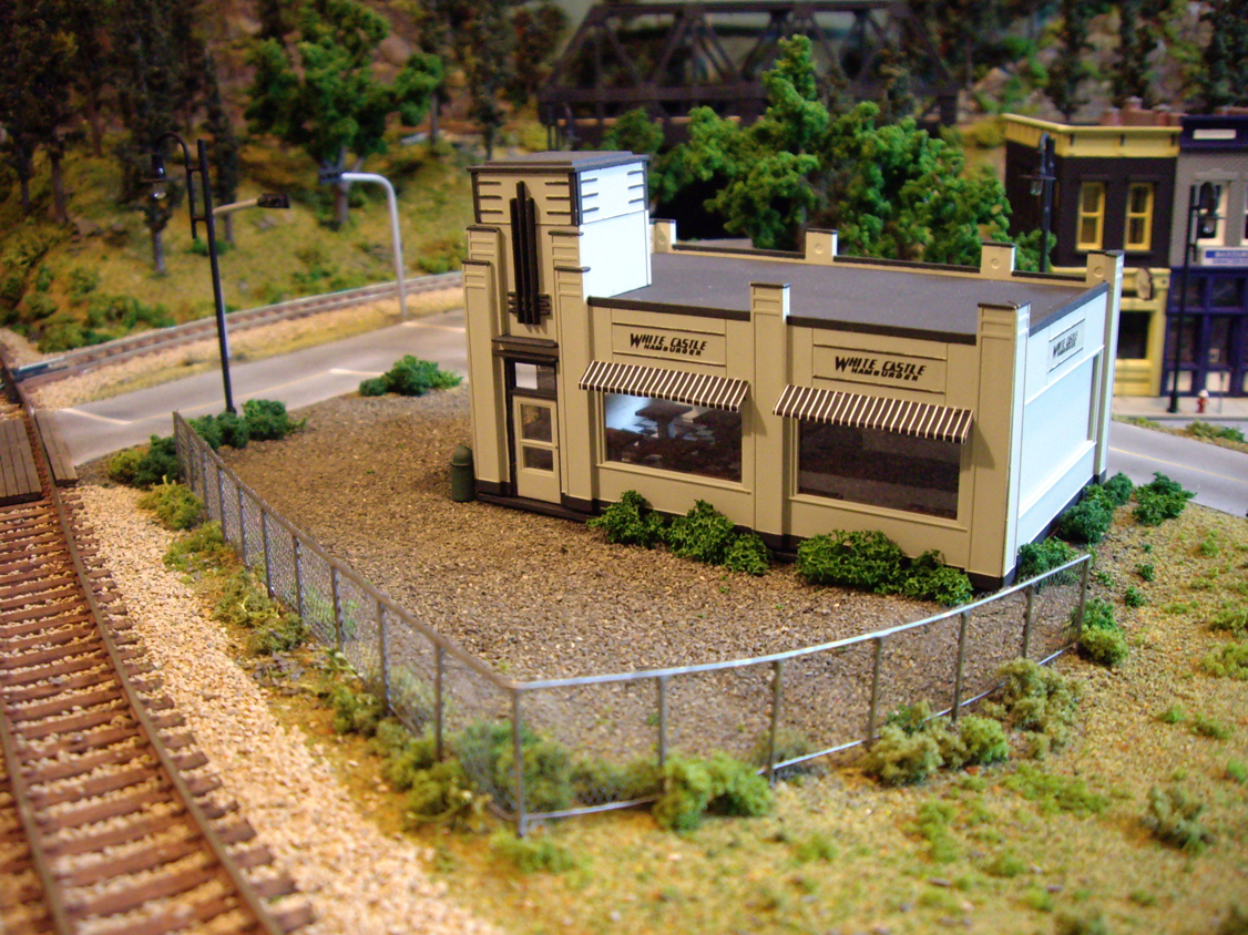 A scratch built chain link fence installed between railroad track and an Atlas White Castle kit