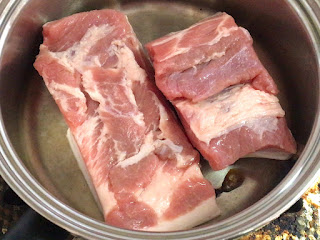豚バラブロックを２つに切って鍋で焼く