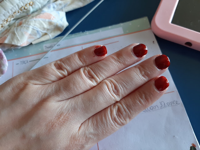 A zoom out picture of a hand with the nails painted of chocolate syrup nail enamel