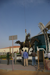 Once again the giant bronze horse statue is rigged to a crane.