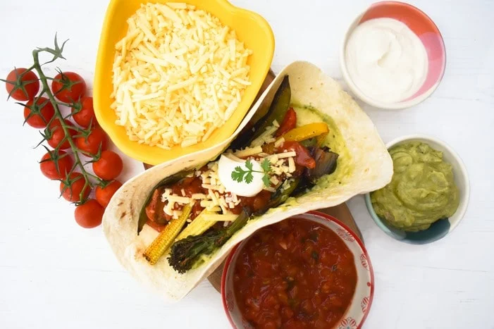 Sheet Pan Vegetable Fajita surrounded by toppings in bowls