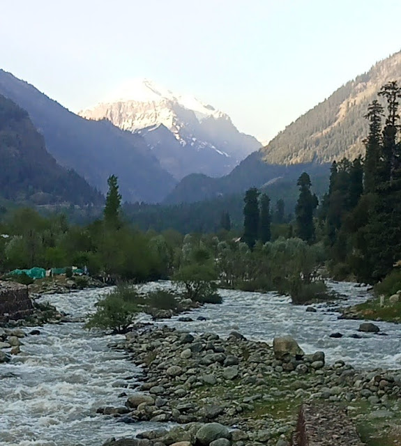 Beautiful scenes of gurgling streams amidat the background of slightly snow-clad mountains