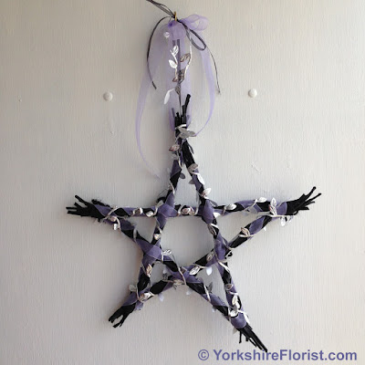  black wooden hanging star with purple and silver ribbon