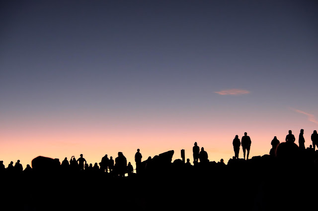 Silhouettes of people watching a sunrise over Haleakala.