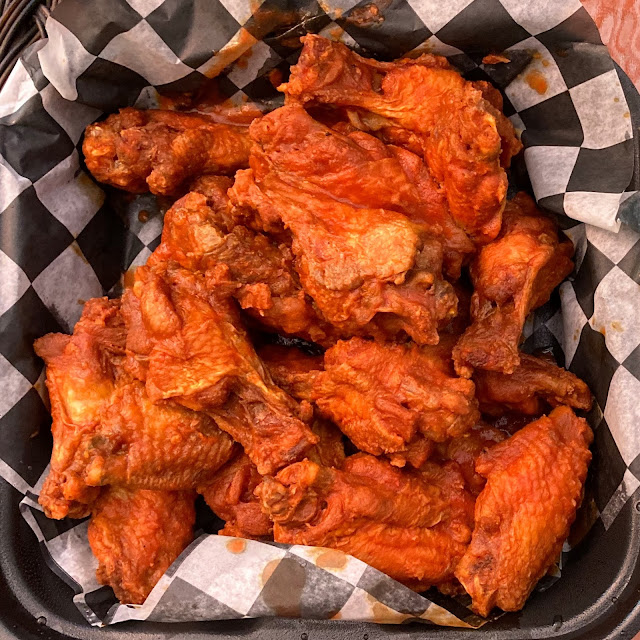 Top view of Duff's Buffalo wings in a black and checkered takeout container