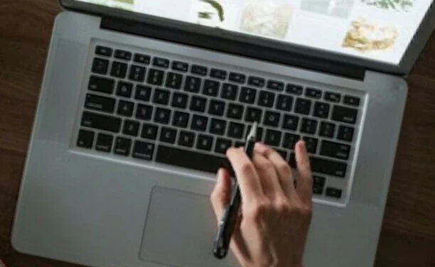 seorang blogger menuliskan ide posting di laptop
