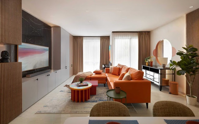 Ruang tamu elegan dengan sofa krem, perabotan kayu, dan tanaman hias.