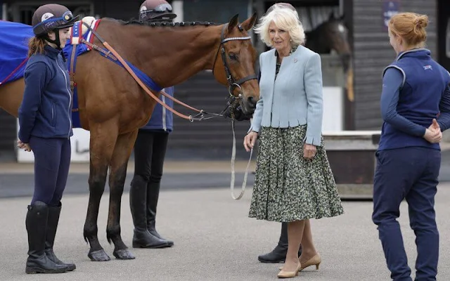 Queen Camilla wore a green floral print midi dress anad light blue wool jacket. Gold brooch