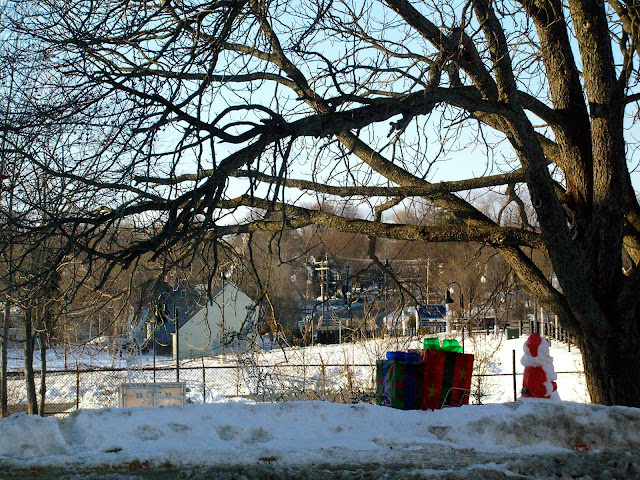 Plastic Santa Claus and presents on a snow bank in Laconia, New Hampshire.