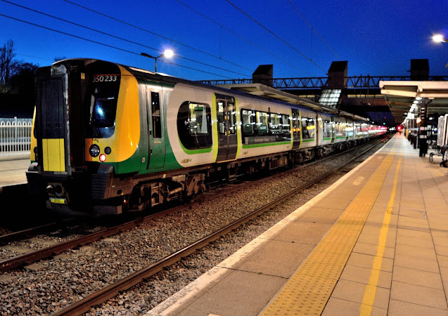 colourful night image of class 350233 london midland uk passenger train waits at bletchley station 2018