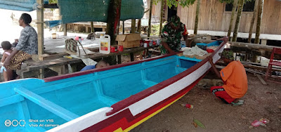 Sertu Marthen Terlihat Serius Memperbaiki Perahu Milik Salah Satu Warga