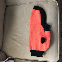 orange dog sweater with black trim.