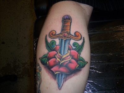 Rose and dagger on forearm tattoo