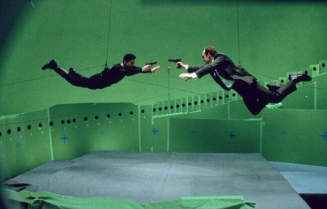 60 Iconic Behind-The-Scenes Pictures Of Actors That Underline The Difference Between Movies And Reality - Keanu Reeves and Hugo Weaving flying away shooting for Matrix.